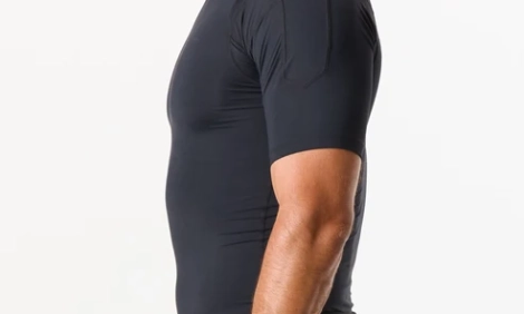 Black custom compression shirt with short sleeves and flatlock seams, worn by an athlete